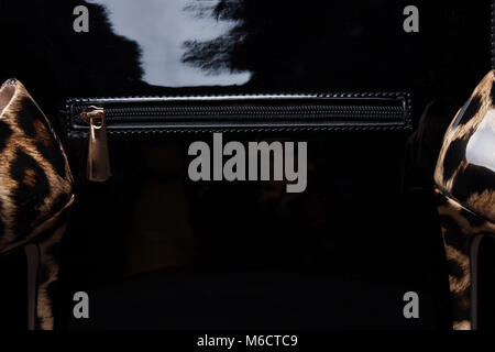 Schwarze Handtasche und Frauen Schuhe, close-up. tiger. Stockfoto