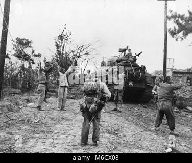 Vier Nordkoreanischen kommunistischen Gefangenen, während der Kämpfe nach der amerikanischen Landung am Wolmi-do sind durch US-Marines abgedeckt. Wolmi Island, Korea, 1950. Verteidigungsministerium Stockfoto