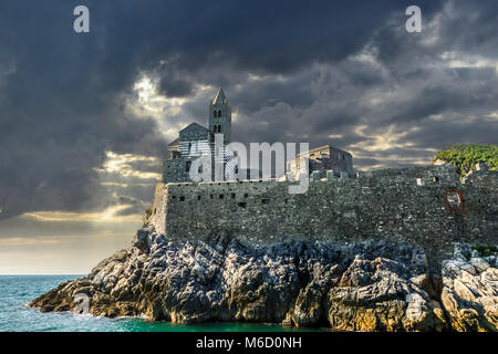 Die imposante Klippen Kirche St. Peter oder San Pietro Kirche im Dorf Portovenere Italien, im Golf der Poeten, mit Sturm, Wolken und Sonne Stockfoto