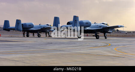 Mannschaft Leiter und Waffen Flieger zugeordnet die 303Rd Expeditionary Jagdgeschwader arm die Waffen auf zwei A-10 Thunderbolt IIs vor dem Start am Flugplatz Kandahar, Afghanistan, Jan. 27, 2018 zu. Scharfschaltung Waffen ist die letzte Aufgabe für Wartung Flieger abzuschließen, bevor das Flugzeug nehmen. (U.S. Air Force Foto: Staff Sgt. Trevor Rhynes) Stockfoto