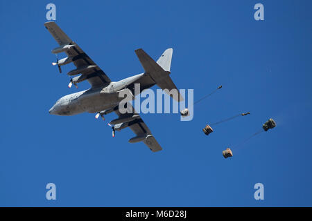 Einer KC-130 T aus marinen Antenne Refueler Transport Squadron 452 Tropfen Cargo als Teil der Container Delivery System Ausbildung in einer Drop Zone in Camp Lejeune, N.C., Jan. 22, 2018. Die Ausbildung simulierten Beförderung von Material, Fahrzeugen und Marines zu einem bestimmten Bereich. (U.S. Marine Corps Foto von Lance Cpl. Ashley McLaughlin) Stockfoto