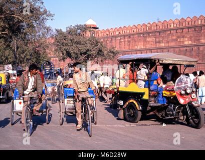 Blick auf das Rote Fort mit der lokalen Bevölkerung auf Fahrrädern und Rikschas im Vordergrund, Delhi, Delhi Union, Indien. Stockfoto