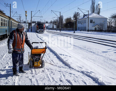 Borispyl, Kiew, Ukraine. 2 Mär, 2018. Ein Arbeiter gesehen, Löschen der Schnee entlang der Bahnstrecke als Hochgeschwindigkeitszug auf der Route Charkow - Kiew führt durch die Station Borispol. Credit: 3026718.jpg /SOPA Images/ZUMA Draht/Alamy leben Nachrichten Stockfoto