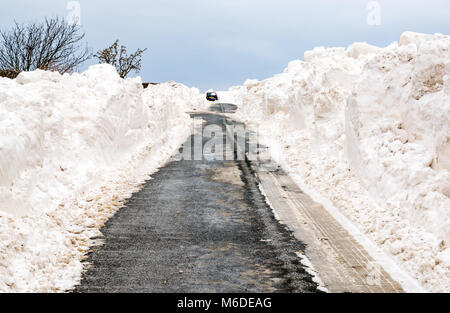 East Lothian, Schottland, Vereinigtes Königreich, 3. März 2018. UK Wetter: Die lokale Straße zwischen Drem und Haddington wird durch große Schneeverwehungen geschlossen, nachdem die extremen arktischen Wetter event Spitznamen "das Tier aus dem Osten". Ein Auto ist in einem snowbank klemmt Stockfoto