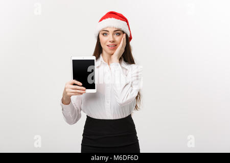 Geschäftskonzept - Junge kaukasier Business woman in Weihnachten Thema anzeigen digital Tablet mit überraschenden Gesichtsausdruck. Stockfoto