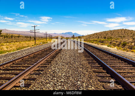 Eisenbahnschienen durch die Mojave Wüste in Kalifornien mit einer wunderschönen Aussicht Stockfoto