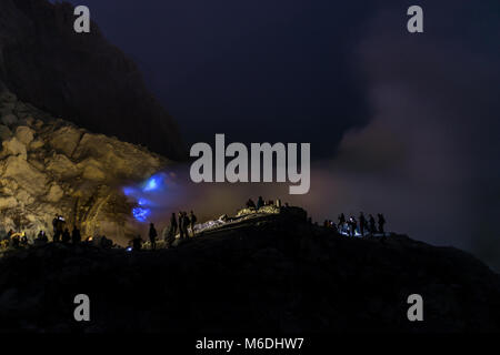 Die blauen Flammen von Schwefel unter den Felsen des Ijen Krater in der Nacht, Indonesien Stockfoto