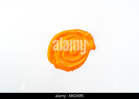 Einen Tropfen Acryl orange Farbe auf einer weißen Fläche Stockfoto