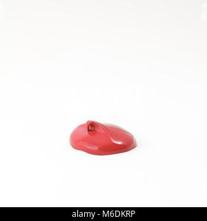 Einen Tropfen Acryl rot Farbe auf einer weißen Fläche Stockfoto