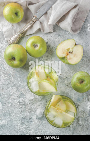 Sour Apple Cocktail oder Infundiert detox Wasser, kalten Sommer trinken. Am grauen Stein Tabelle kopieren Raum, Ansicht von oben Stockfoto