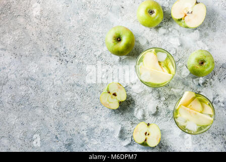 Sour Apple Cocktail oder Infundiert detox Wasser, kalten Sommer trinken. Am grauen Stein Tabelle kopieren Raum, Ansicht von oben Stockfoto
