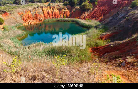 Der See in roten Böden ist eine alte Bauxit Steinbruch Höhle in Apulien, Salento, Otranto, Italien. Der Graben wurde mit natürlichem Wasser gefüllt. Stockfoto