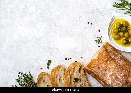 Italienische ciabatta Brot in Scheiben geschnitten mit Kräutern und Oliven. Stockfoto