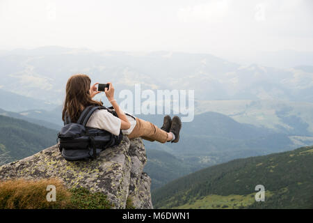 Wanderer Mädchen mit Rucksack, Self Portrait in der wunderschönen Landschaft auf einem Felsen in der Ukrainischen Karpaten Stockfoto