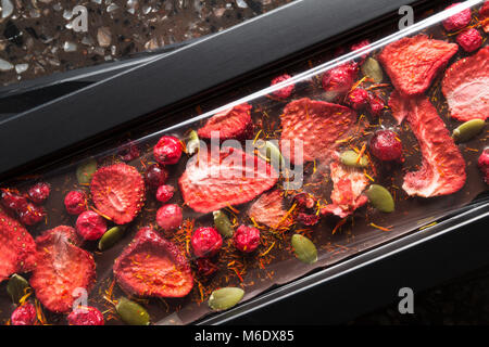 Handgemachte Schokolade mit getrockneten Erdbeeren, Cranberry und Kürbiskerne Stockfoto