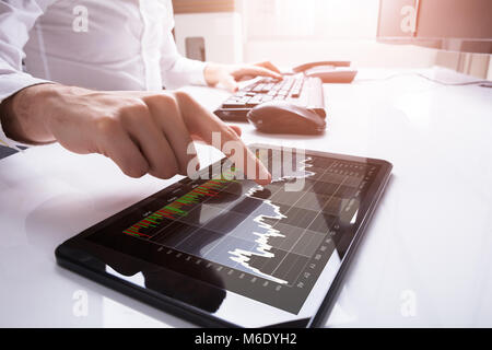 Nahaufnahme der Kaufmann Finger berühren Digitalen Tablet Bildschirm mit Diagrammen Stockfoto