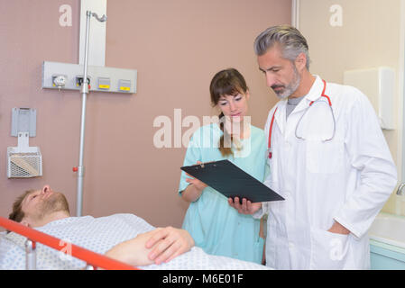 Doktor Lesung Zwischenablage mit Kollegen Vorbereitung patient für ct Stockfoto