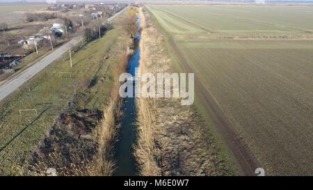 Der Kanal der unteren Ebene der Bewässerung der Felder. Infrastruktur für den Anbau von Reis. Stockfoto