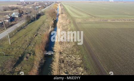 Der Kanal der unteren Ebene der Bewässerung der Felder. Infrastruktur für den Anbau von Reis. Stockfoto