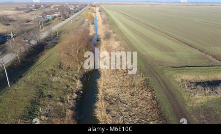 Der Kanal der unteren Ebene der Bewässerung der Felder. Infrastruktur für den Anbau von Reis. Stockfoto