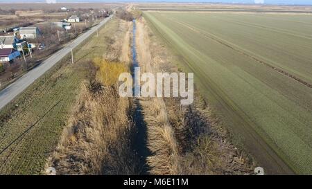 Der Kanal der unteren Ebene der Bewässerung der Felder. Infrastruktur für den Anbau von Reis. Stockfoto