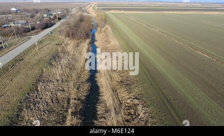 Der Kanal der unteren Ebene der Bewässerung der Felder. Infrastruktur für den Anbau von Reis. Stockfoto