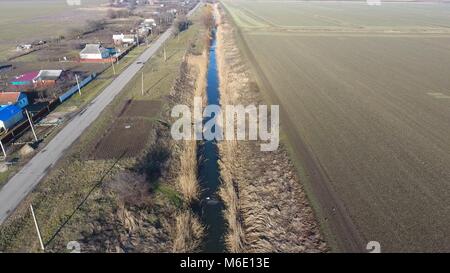 Der Kanal der unteren Ebene der Bewässerung der Felder. Infrastruktur für den Anbau von Reis. Stockfoto