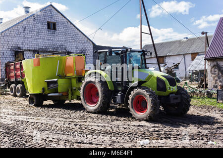 Landwirtschaftliche Maschinen und Anlagen. Den Traktor mit Verteiler von gemischtem Futter für die Kühe. Der Hof von einem Milchviehbetrieb. Podlachien, Polen. Stockfoto