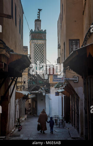 Vater und Sohn, in Tala Kebira Straße, im Hintergrund das Minarett der Moschee Chrabliyine. Fes. Marokko Stockfoto