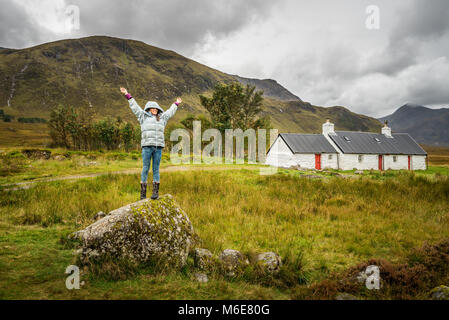 Frau, die mit offenen Armen gegen die Kulisse der Berge Stockfoto