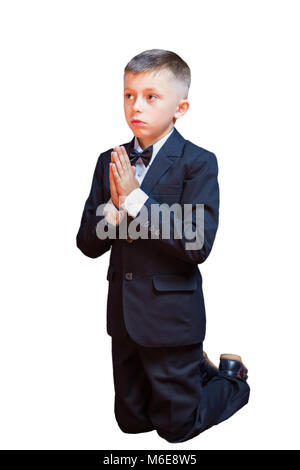 Ein kleiner Junge in einem Anzug zu beten, auf einem weißen Hintergrund. Traditionell, Kinder nehmen die erste Gemeinschaft in der Kirche. Stockfoto