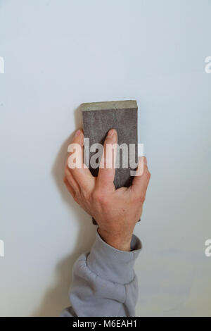 Master Gipser glättet die Nähte mit Gips zwischen Gips Platten an der Wand. Gips in der Form einer Welle an der Wand. Stockfoto