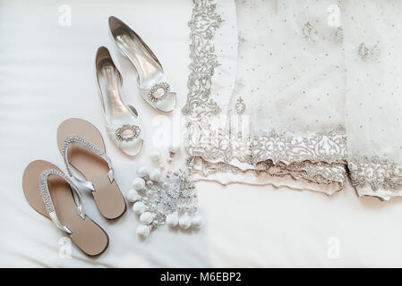 Schuhe der indischen Braut und Sari in Weiß. Stockfoto