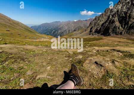 Tien Shen Berge bei Shymbulak oberen Piste Talgar Pass in der Nähe von Almaty, Kazakhstanl Beine im Vordergrund. Stockfoto