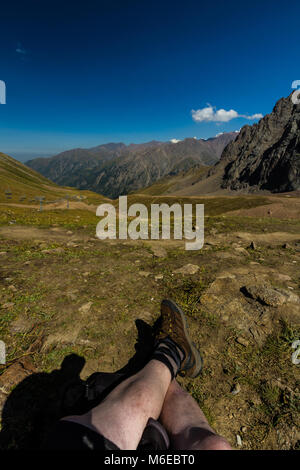 Tien Shen Berge bei Shymbulak oberen Piste Talgar Pass in der Nähe von Almaty, Kazakhstanl Beine im Vordergrund. Stockfoto