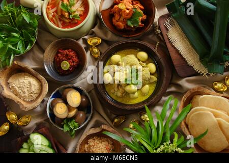 Lontong Cap klicken Sie meh. Die Javanese-Peranakan Reis Kuchen Suppe mit Hähnchen Curry, Chayote Squash Curry Soja, Ei, Garnelen Eintopf, Boden Soja- und Cracker. Stockfoto