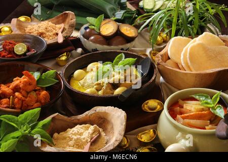 Lontong Cap klicken Sie meh. Die Javanese-Peranakan Reis Kuchen Suppe mit Hähnchen Curry, Chayote Squash Curry Soja, Ei, Garnelen Eintopf, Boden Soja- und Cracker. Stockfoto