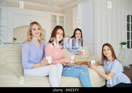 Eine Gruppe von Freunden der jungen Mädchen sprechen bei einem Treffen in einem Zimmer im Innenbereich. Stockfoto