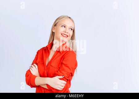 Junge blonde Mädchen in Freizeitkleidung schaut auf grauen Hintergrund. Stockfoto