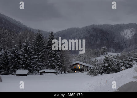 Schneebedeckte Landschaft mit einem Ferienhaus in der frühen Dämmerung. Savinjska Region; Stajerska (Steiermark) Slowenien Stockfoto