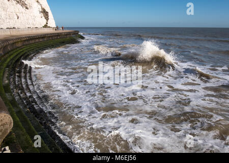 Die Flut an der Waterfront Pfad in der Nähe von Cranbrook mit dem Meer Läppen auf der Promenade Schritte zum Sandstrand. Stockfoto