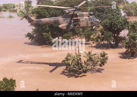 Überschwemmungen in Mosambik, März 2000; eine Südafrikanische Luftwaffe Hubschrauber rettet gestrandete Menschen von Dächern in der Nähe von Gaza Chibuto, Provinz. Stockfoto