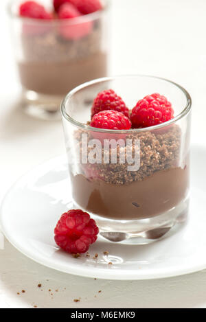 Dessert Schokolade in Gläsern mit Himbeeren. Mousse au Chocolat oder Pudding in Teil Gläser mit frischen Beeren, kopieren. Stockfoto