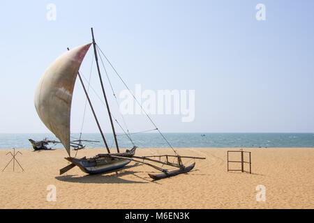 Oruwa fischen Katamaran oder einem traditionellen srilankischen Fischerboot in Form eines Outrigger Kanu auf einem leeren Strand in Negombo, Sri Lanka Stockfoto