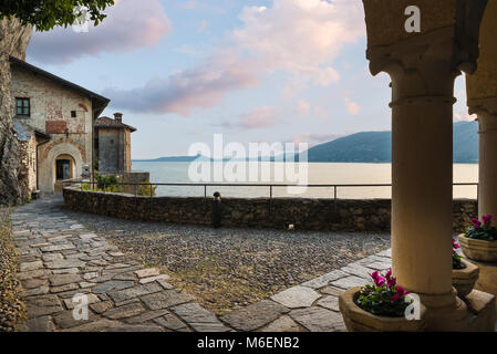 Alte einsiedelei am Lago Maggiore, Italien. Malerische Aussicht, Einsiedelei Santa Caterina del Sasso bei Sonnenuntergang Stockfoto