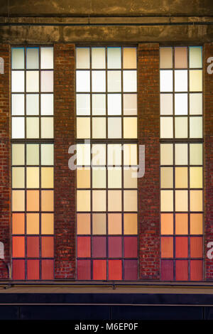 Alte farbige Fenster mit warmen Farbtönen. Rote, orange, gelbe Quadrate. Stockfoto