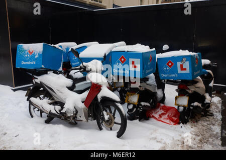 Schnee, der Domino's Pizza Mopeds außerhalb des Restaurants ist ein Domino, während der Sturm Emma in Bristol. Stockfoto