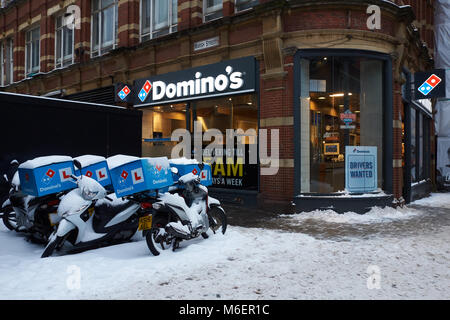 Schnee, der Domino's Pizza Mopeds außerhalb des Restaurants ist ein Domino, während der Sturm Emma in Bristol. Stockfoto