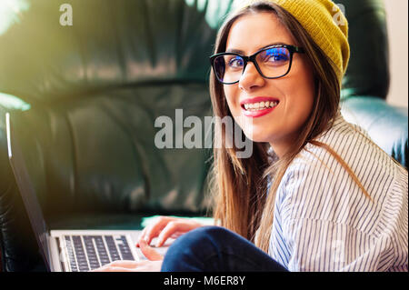 Hipster Frau sitzt auf dem Boden mit einem Laptop Stockfoto