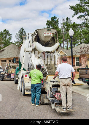 Hodgson Beton Lkw konkrete Auslieferung an den Wohnbau Job mit zwei Arbeiter laden der Zement in einen Eimer in Montgomery, AL, USA. Stockfoto